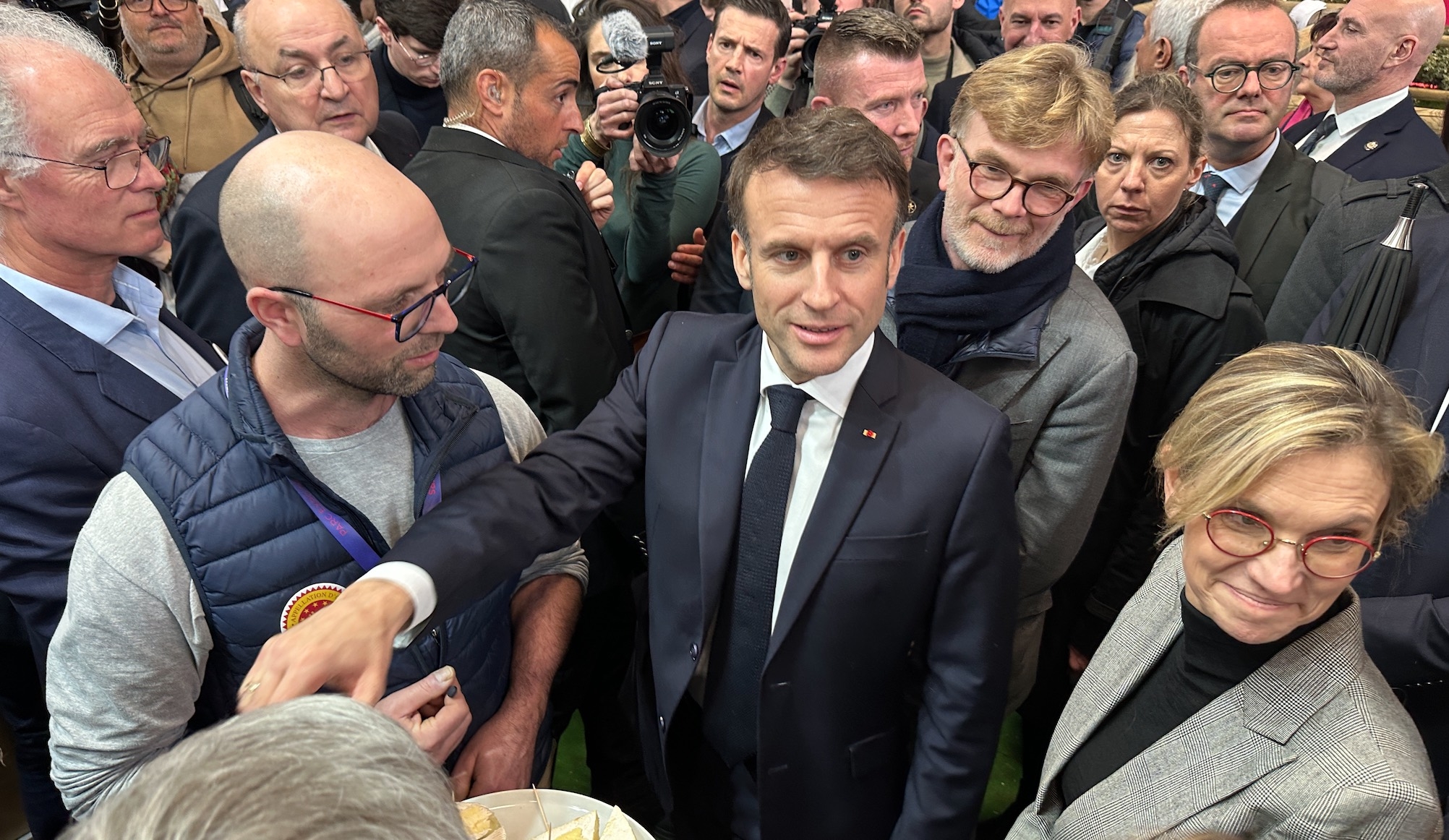 Emmanuel Macron dégustant des fromages de Normandie le 24 février, aux côtés de Marcs Fesneau et Agnès Pannier-Runacher, respectivement ministre de l‘Agriculture et ministre déléguée à l’Agriculture (Crédit photo : R. Lecocq)